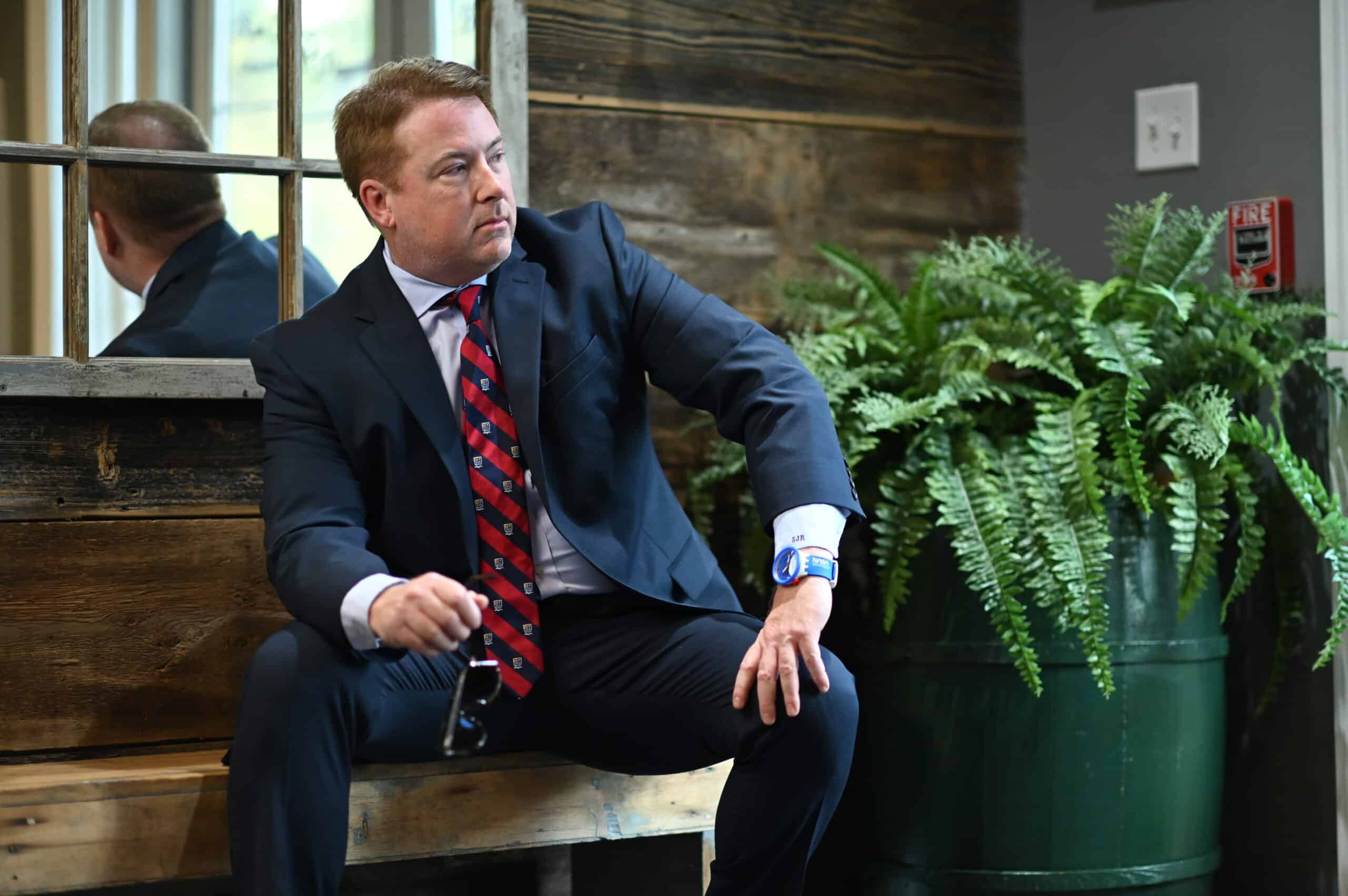 Stephen J. Ross listening to a client while sitting on bench